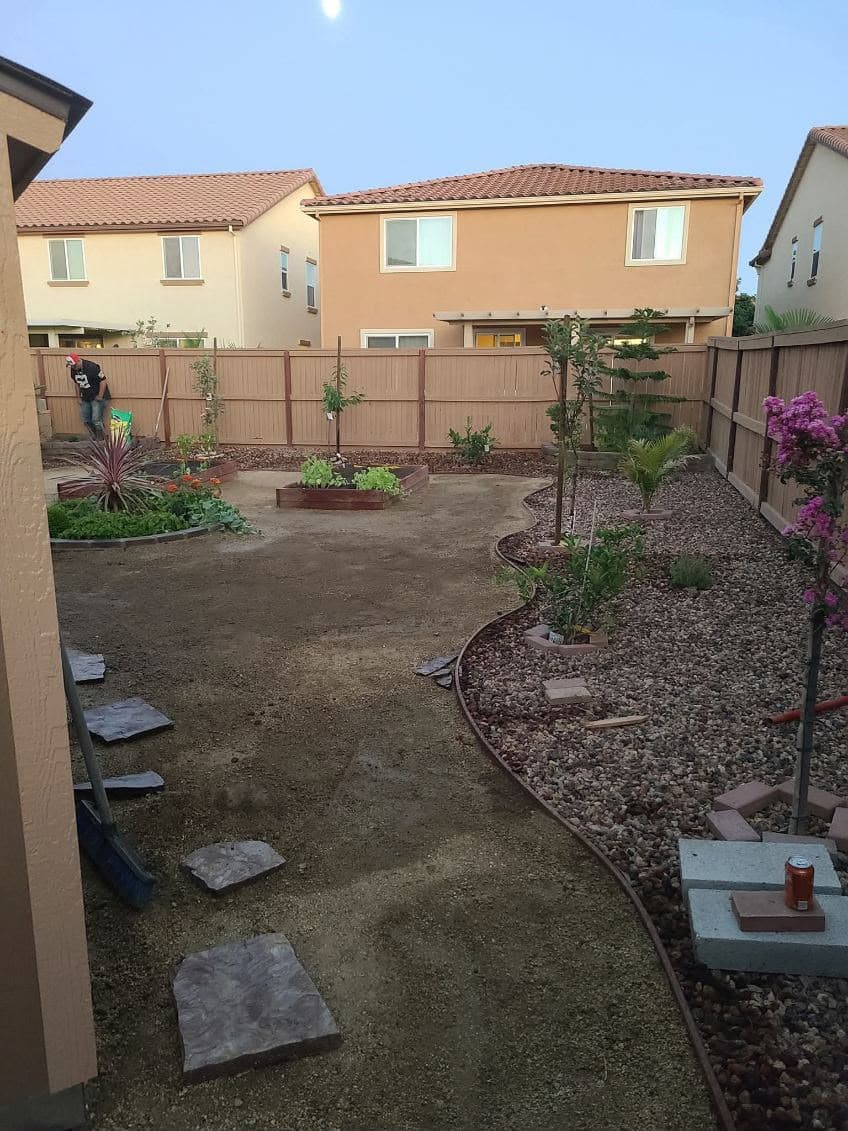 Backyard raised garden bed and gravel hardscape installation with drip irrigation in Sacramento CA
