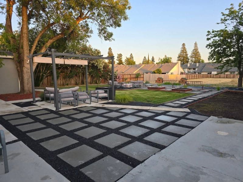 Modern backyard paver patio with pergola and landscape lighting in Sacramento CA